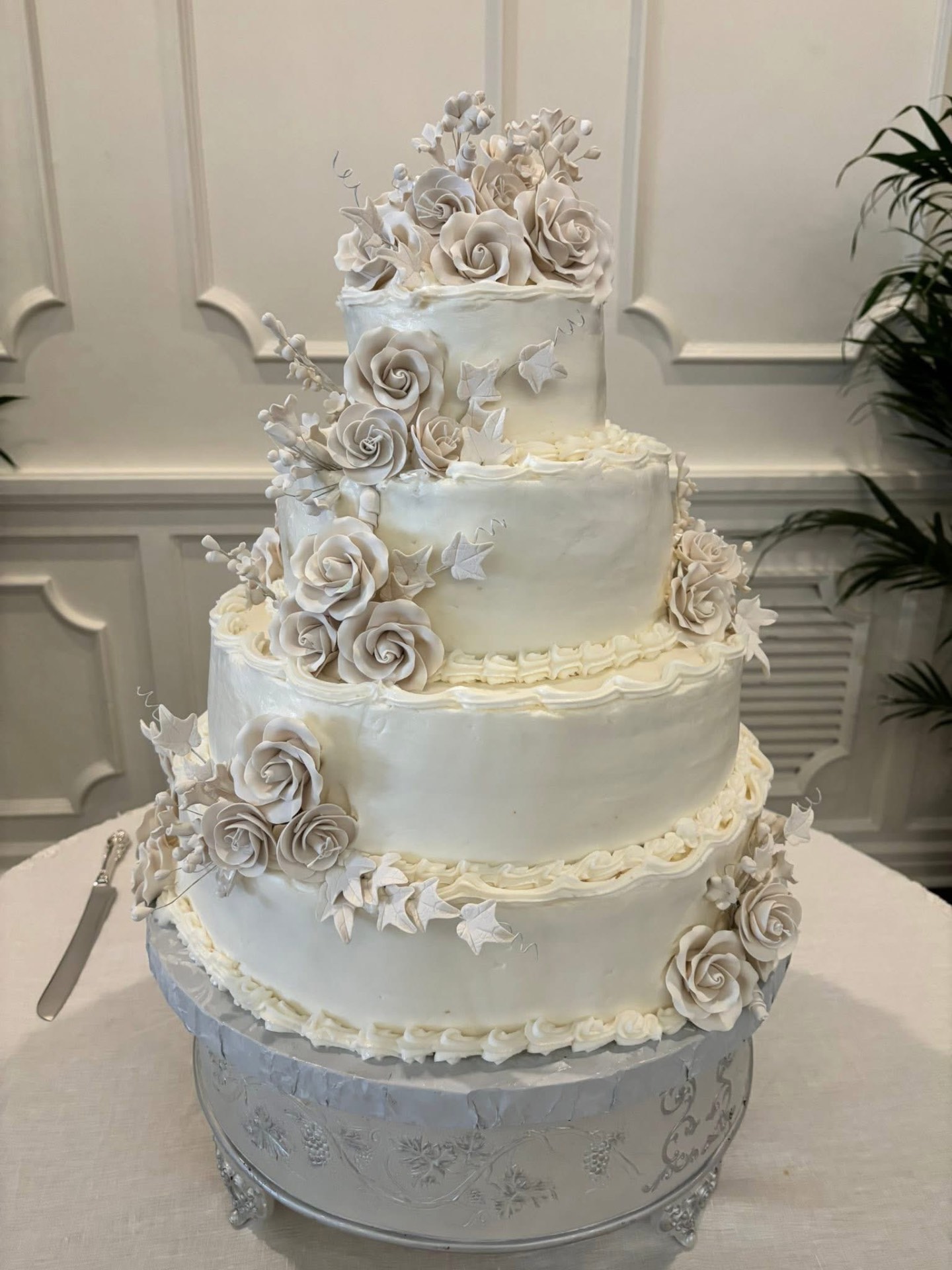 Four-tier ivory wedding cake with cascading sugar roses